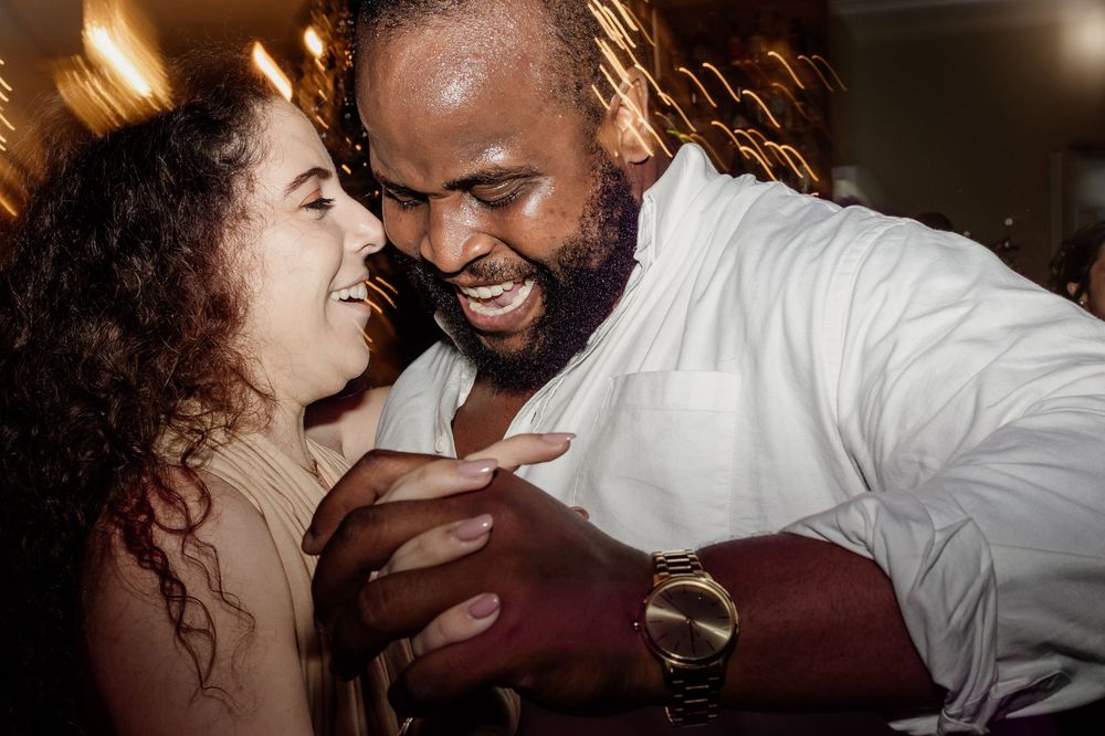 A couple shares an intimate moment while dancing together at an indoor event.