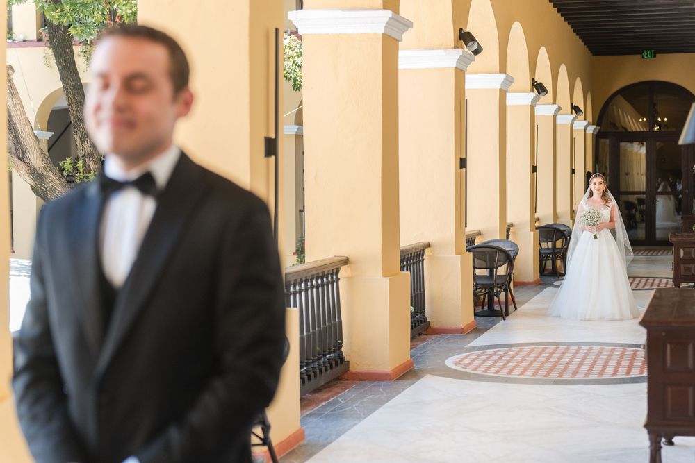 Bride approaching groom from behind during first look at Hotel El Convento