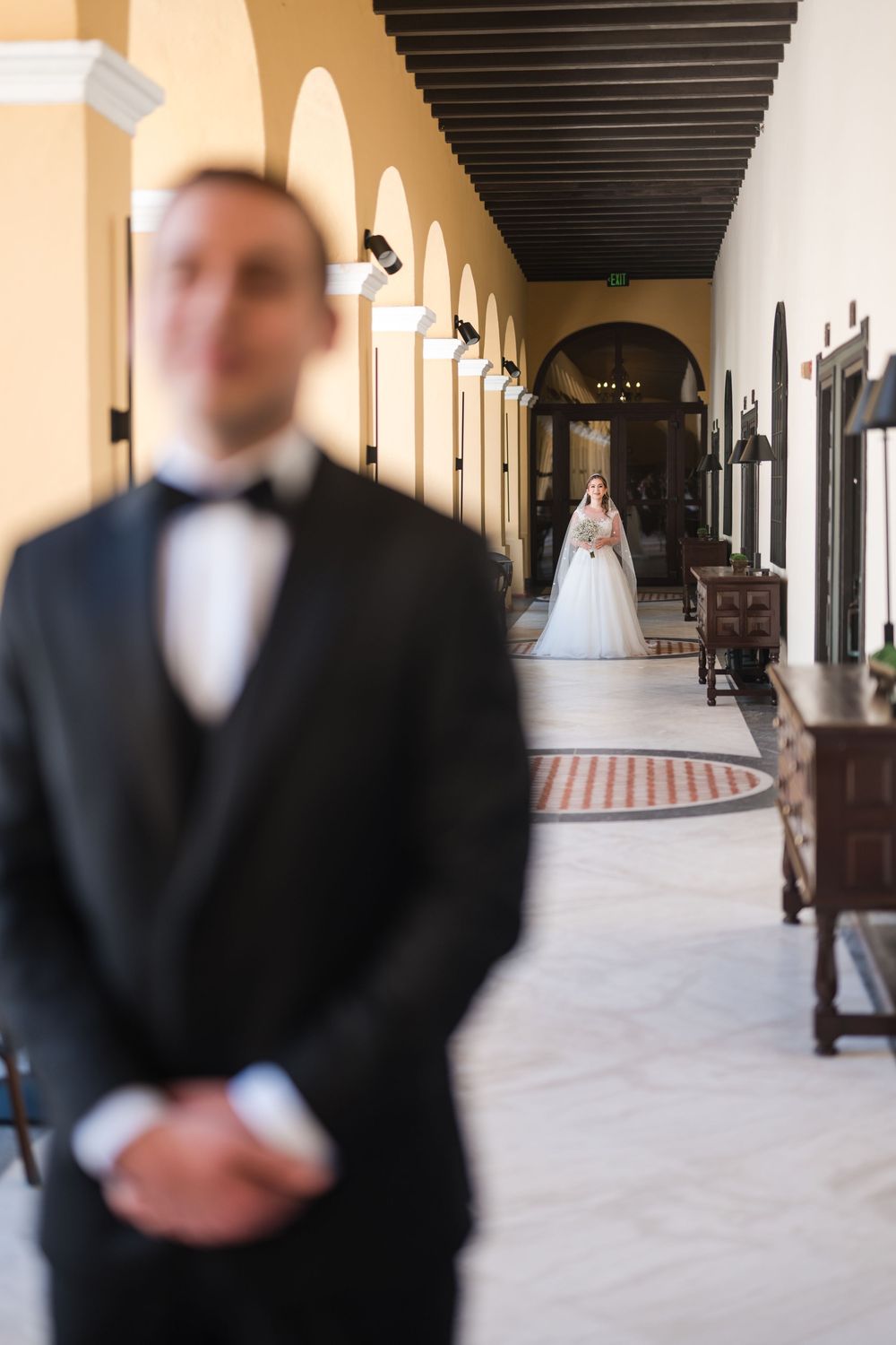 Groom waiting during first look moment in corridor at Hotel El Convento Puerto Rico