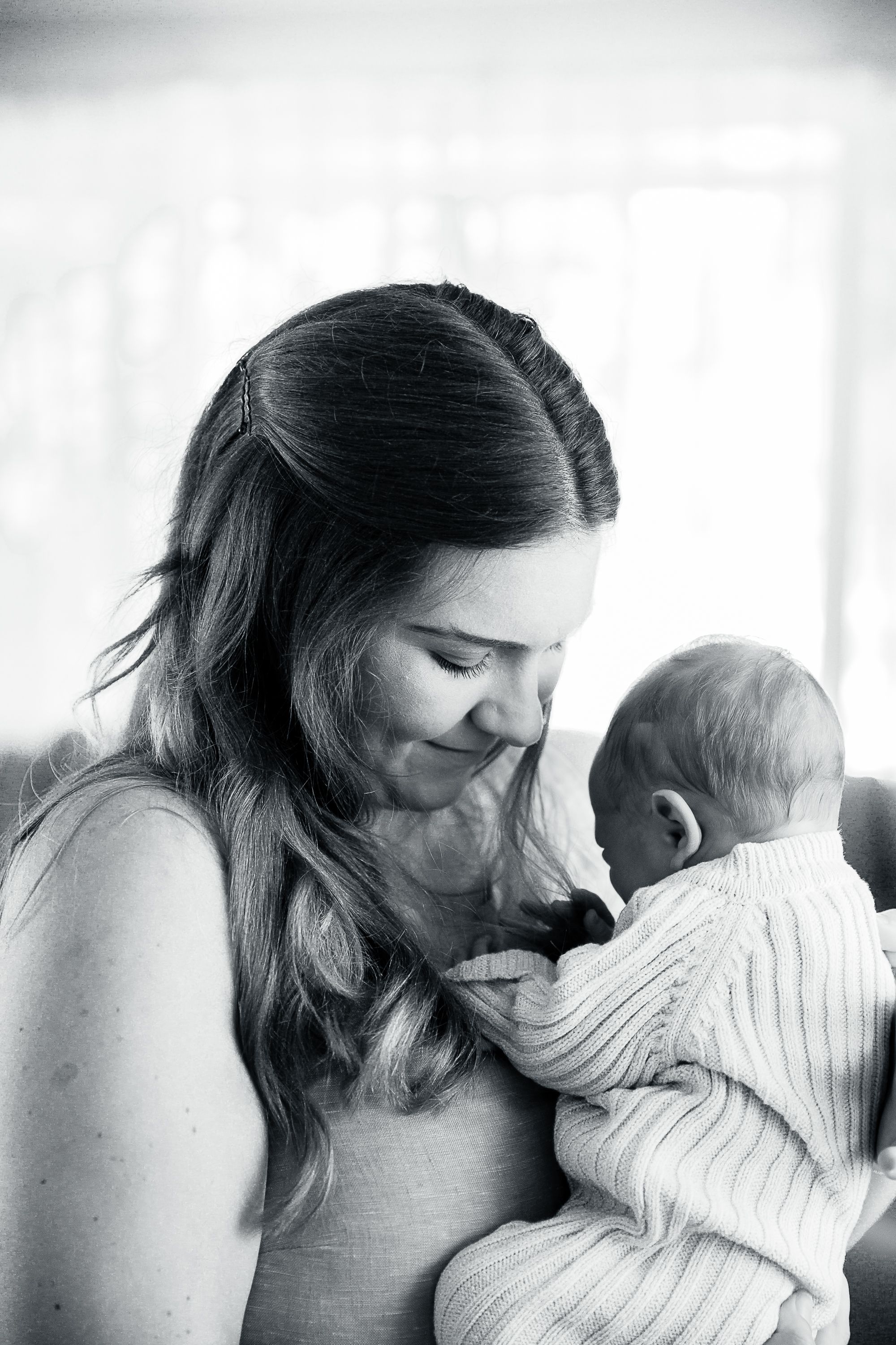 Mum holding new born at new born professional photo shoot