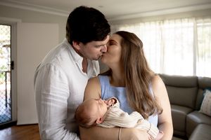 Family photo in lounge room at new born professional photo shoot
