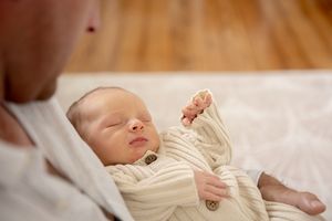 Father nursing son in lounge room at new born professional photo shoot
