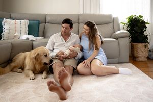 Family photo with dog in lounge room at new born professional photo shoot