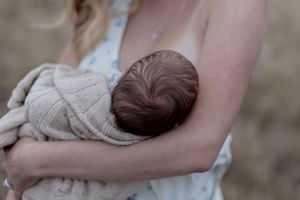 Close up of Mother feeding baby  in professional new born photo session