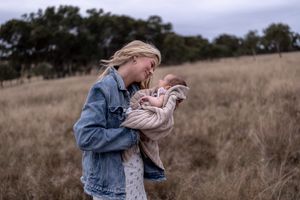 Mother looking lovingly at her new born in professional new born photo session