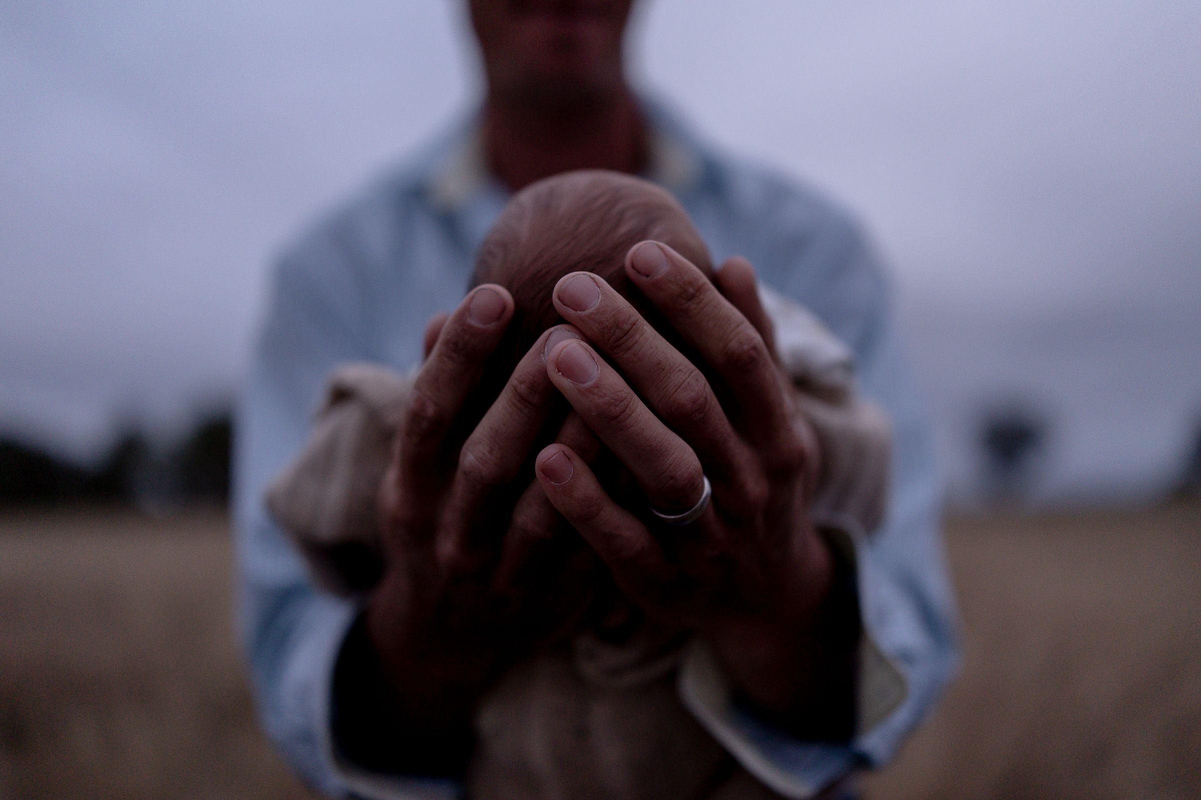 Father holding new born in his hands in professional new born photo session