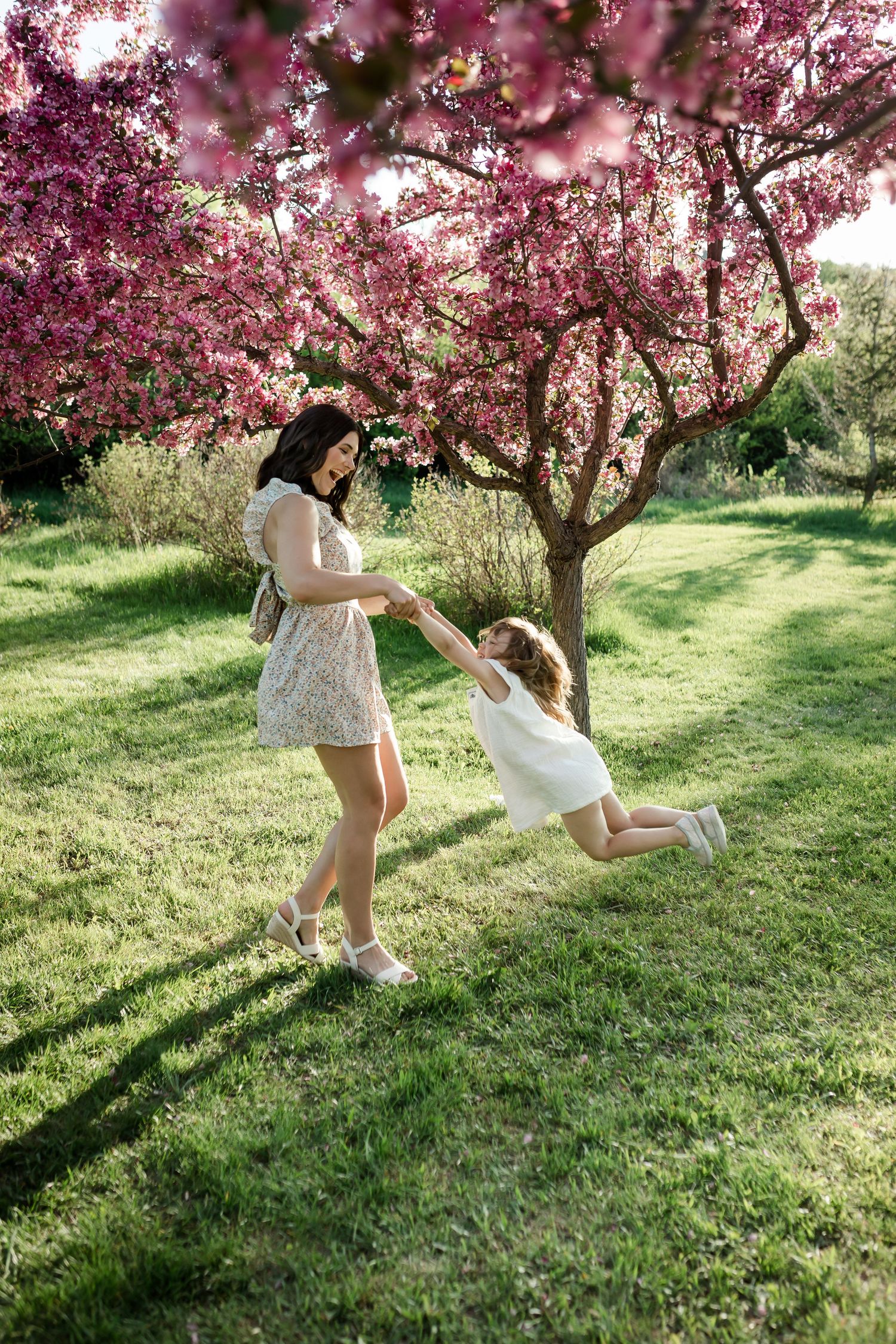 Beautiful motherhood moment in cherry blossoms at spring time by Calgary family photographer, Love & Sunshine Photography.
