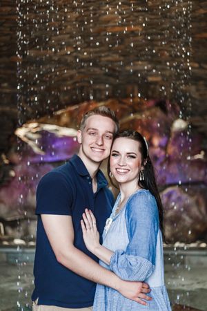 Joyful couple embracing with sparkles and bokeh lighting effects in an indoor setting.