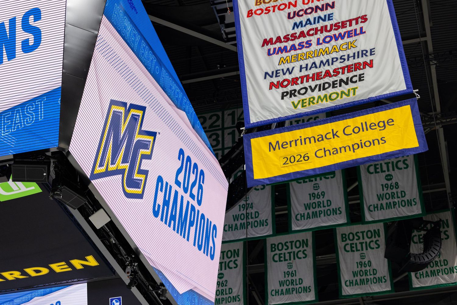 Championship banners hang from arena ceiling displaying college hockey achievements.