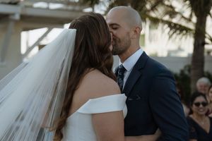 A bride and groom share intimate moments in a series of romantic wedding photos outdoors.