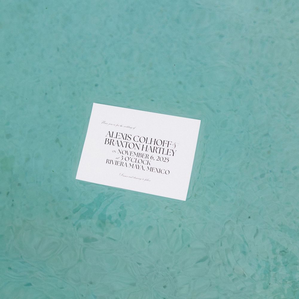 White business cards arranged in a minimalist composition on a turquoise textured background.