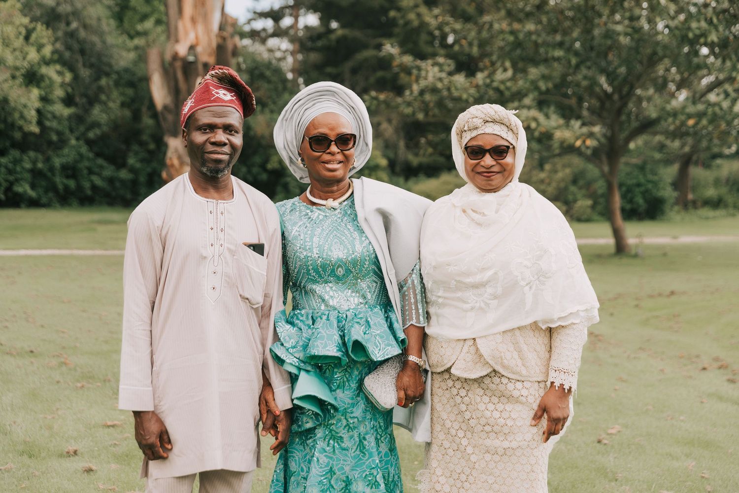 People in coordinated formal attire stand together during an outdoor gathering.