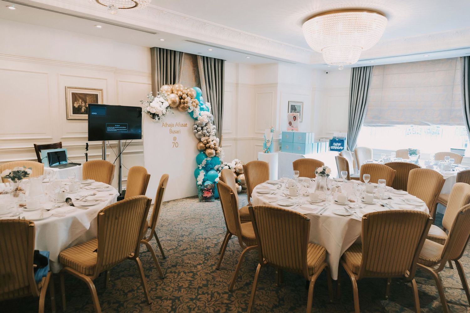 Banquet room setup with round tables covered in white linens and brown wicker chairs for a formal event.