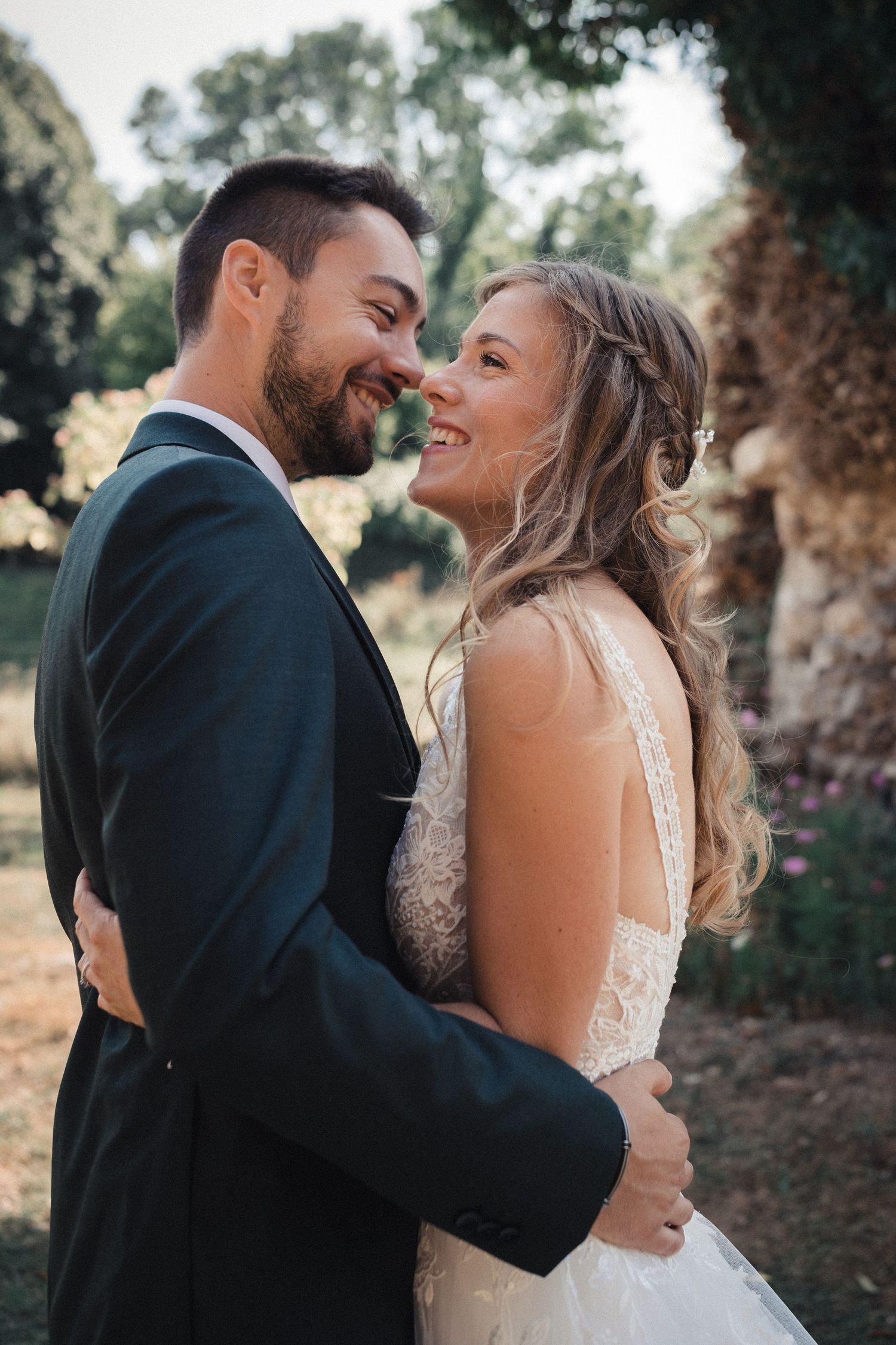 Romantic wedding couple sharing intimate moments in a rustic outdoor setting.
