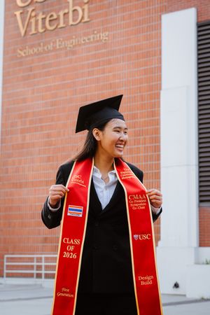 Smiling USC Viterbi School of Engineering graduate wearing cap, gown, and red Class of 2026 stole.