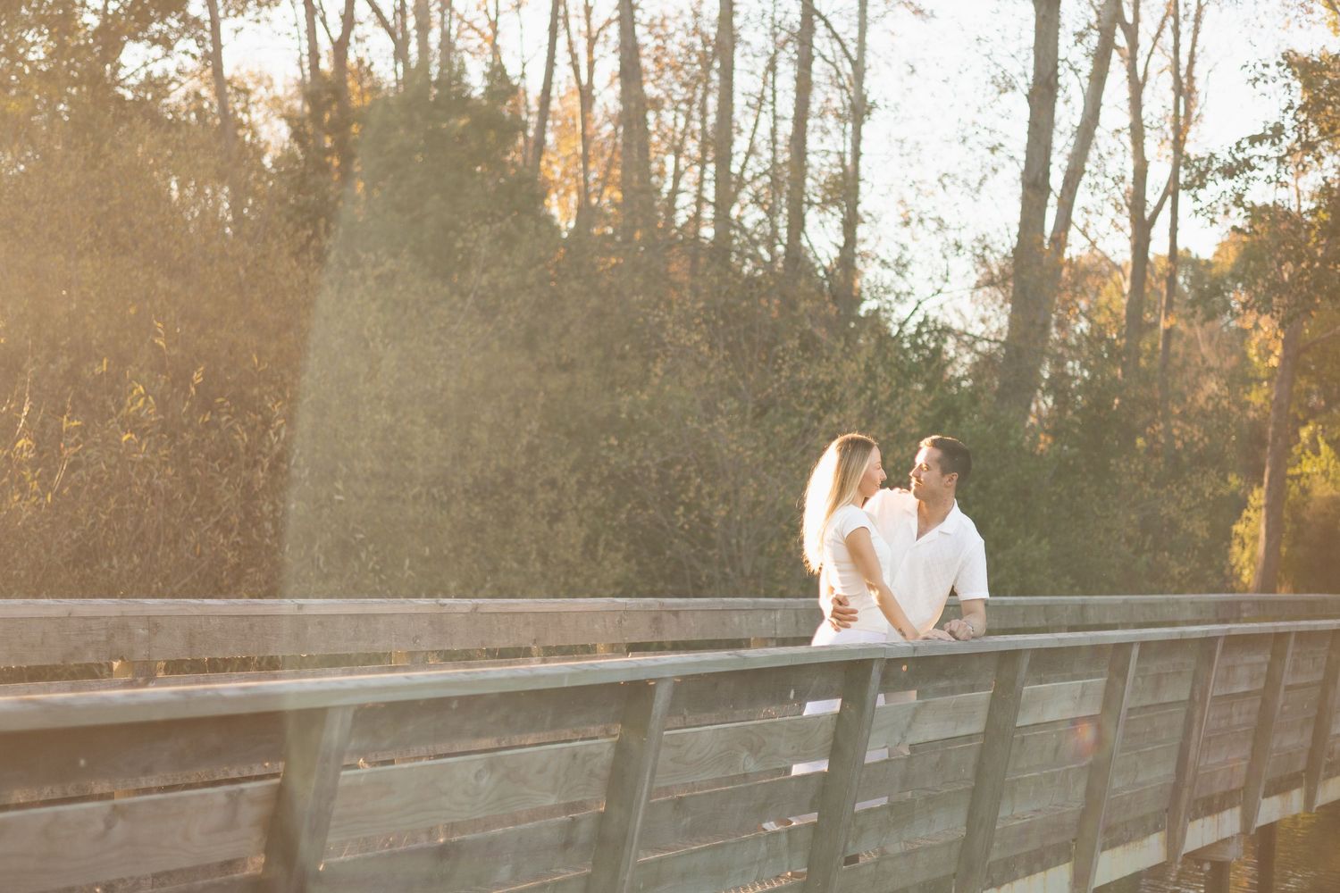 couples standing on the bridge at sunset session at The Groynes,