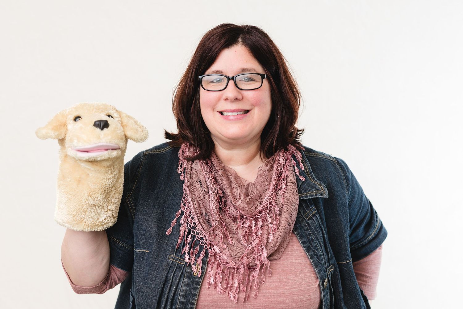 Child wearing a red sweater and hair bows poses for a close-up portrait.