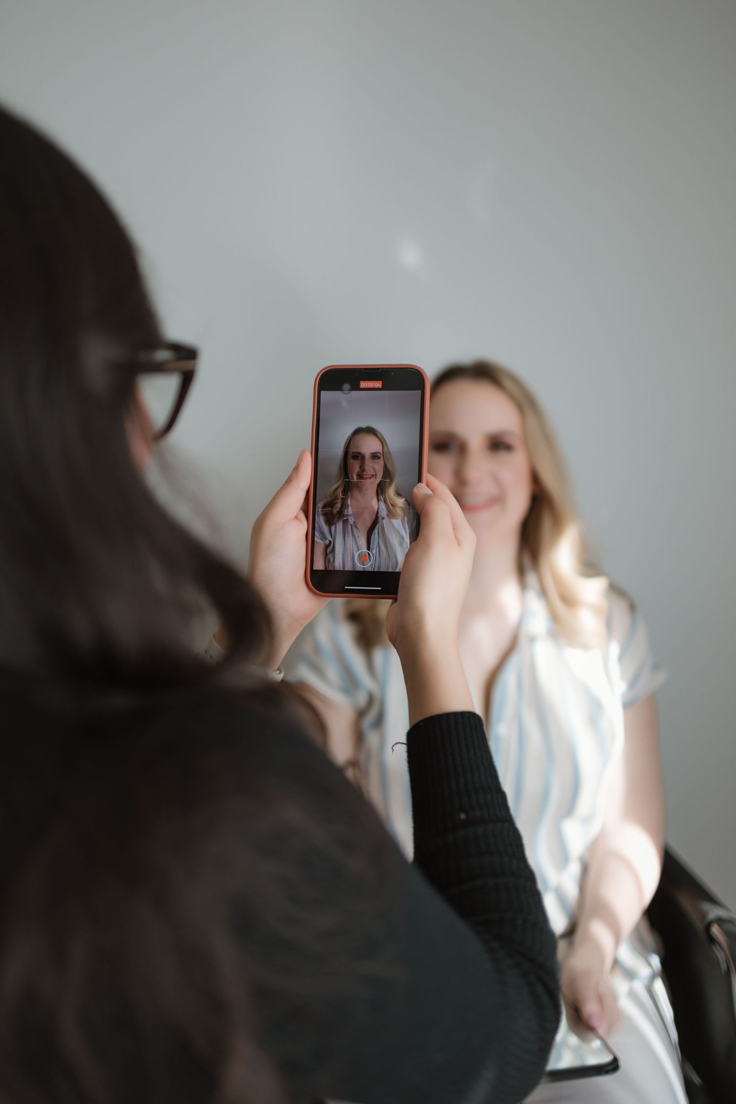 Someone taking a selfie on a smartphone in a sequence of photos showing the process of capturing the image.