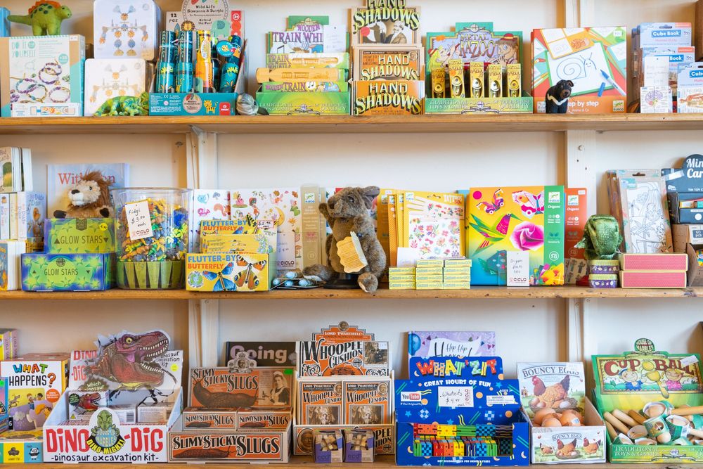 Colorful children's books arranged on wooden shelves at CICLO x Argus House in Strathalbyn