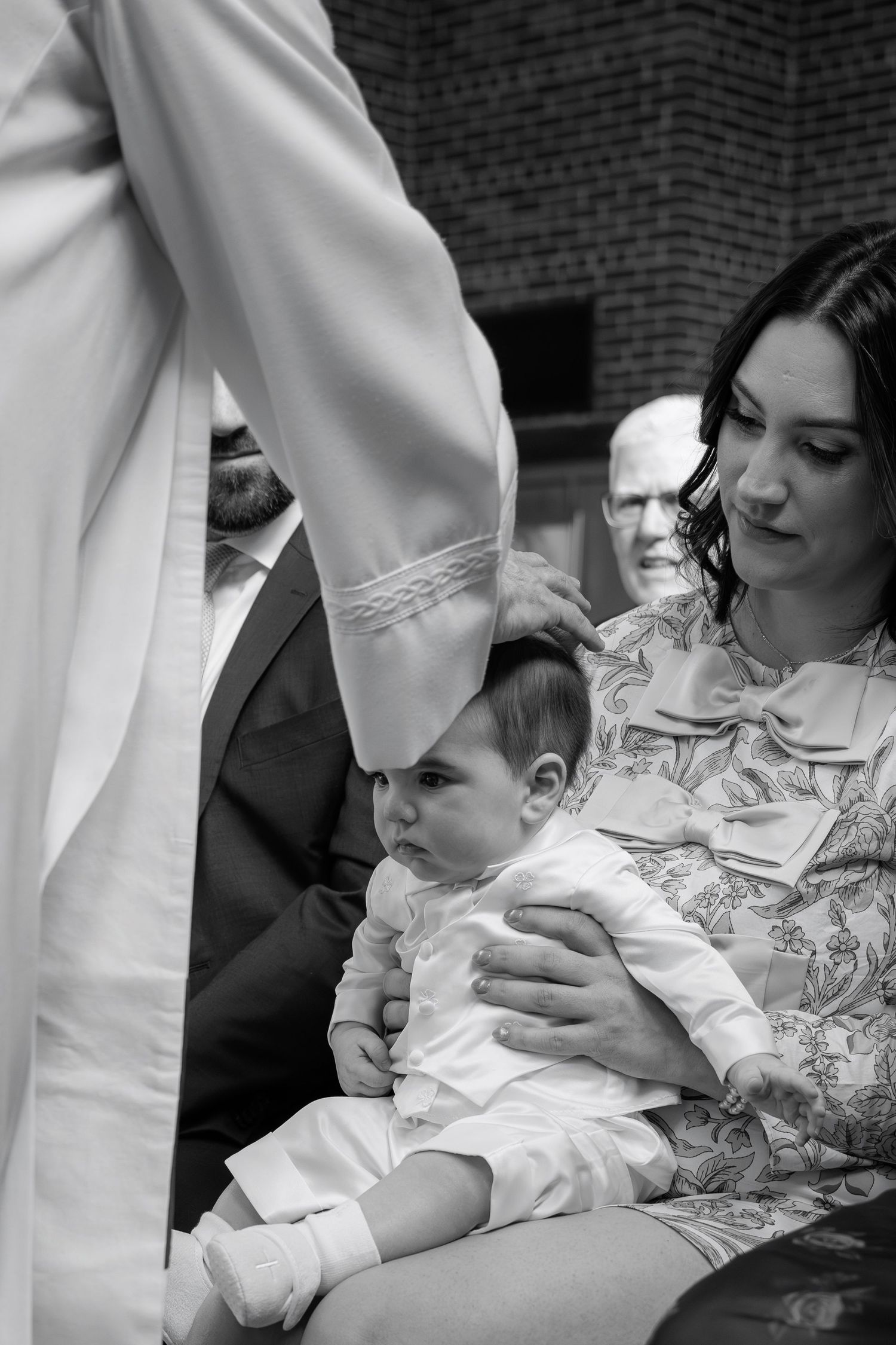 Black and white photo series showing tender moments between parent and newborn baby in hospital setting.