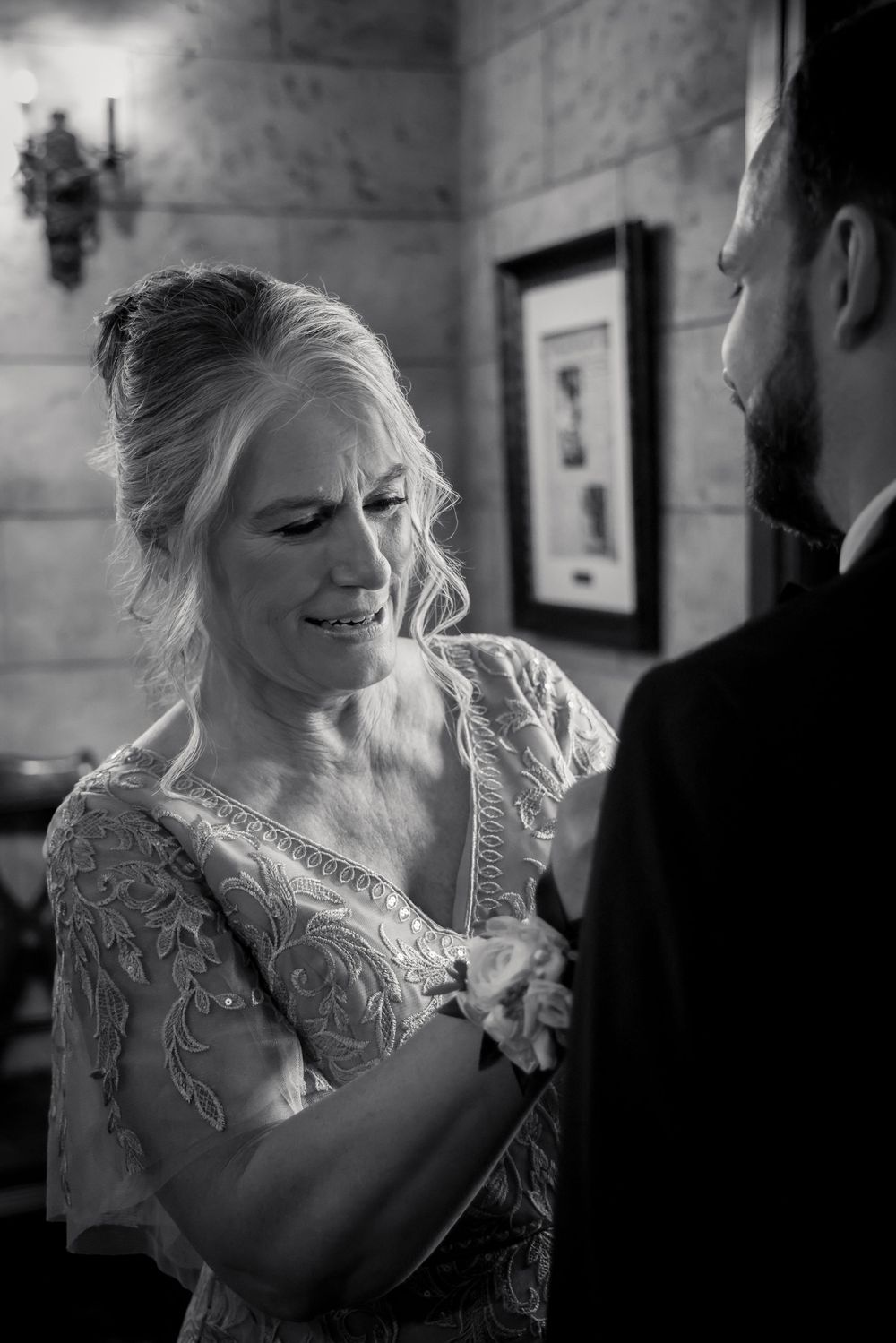 Black and white emotional moment captured during wedding preparations.