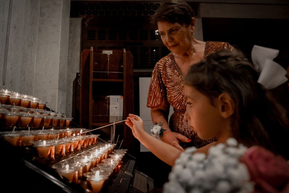 Guests lighting memorial candles during evening wedding reception ceremony.