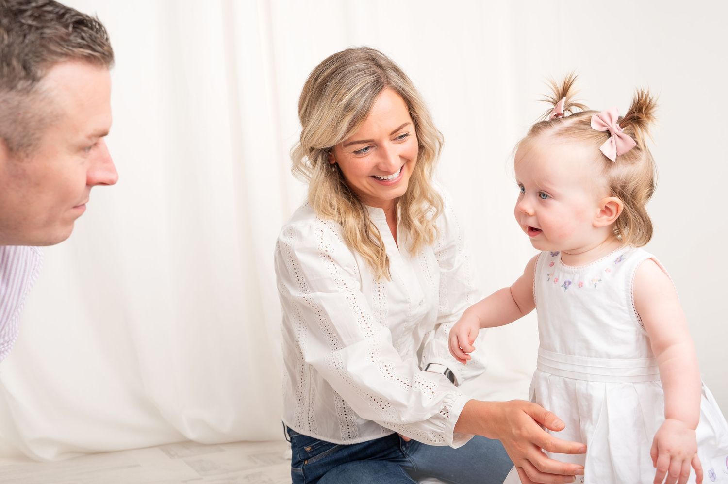 Family shares tender moment together during photography session with white backdrop. Family Portraits. South Lanarkshire Carluke.