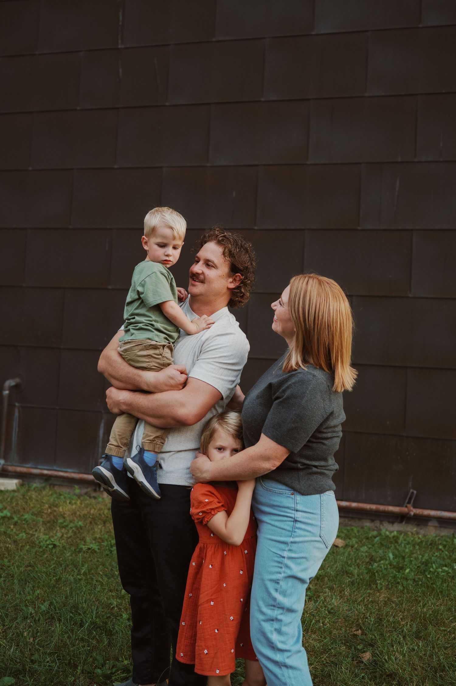 Casual family portrait series with playful interactions in golden fall setting.