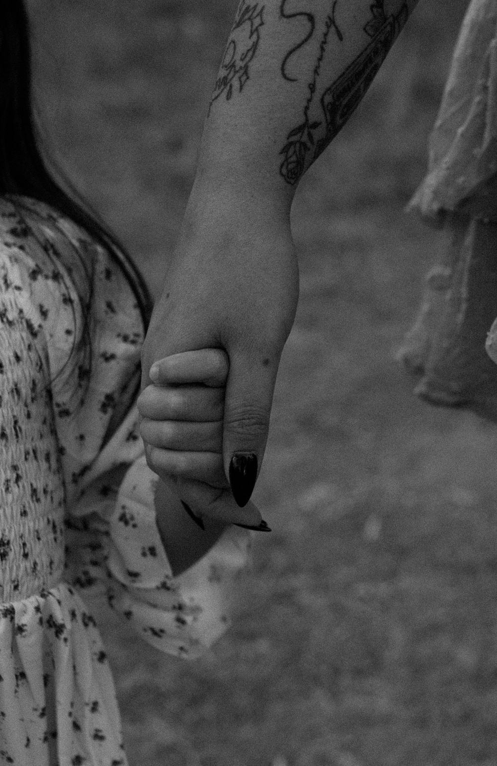 Close-up black and white image of hands holding with visible tattoo artwork. Colorado Springs Photographer.