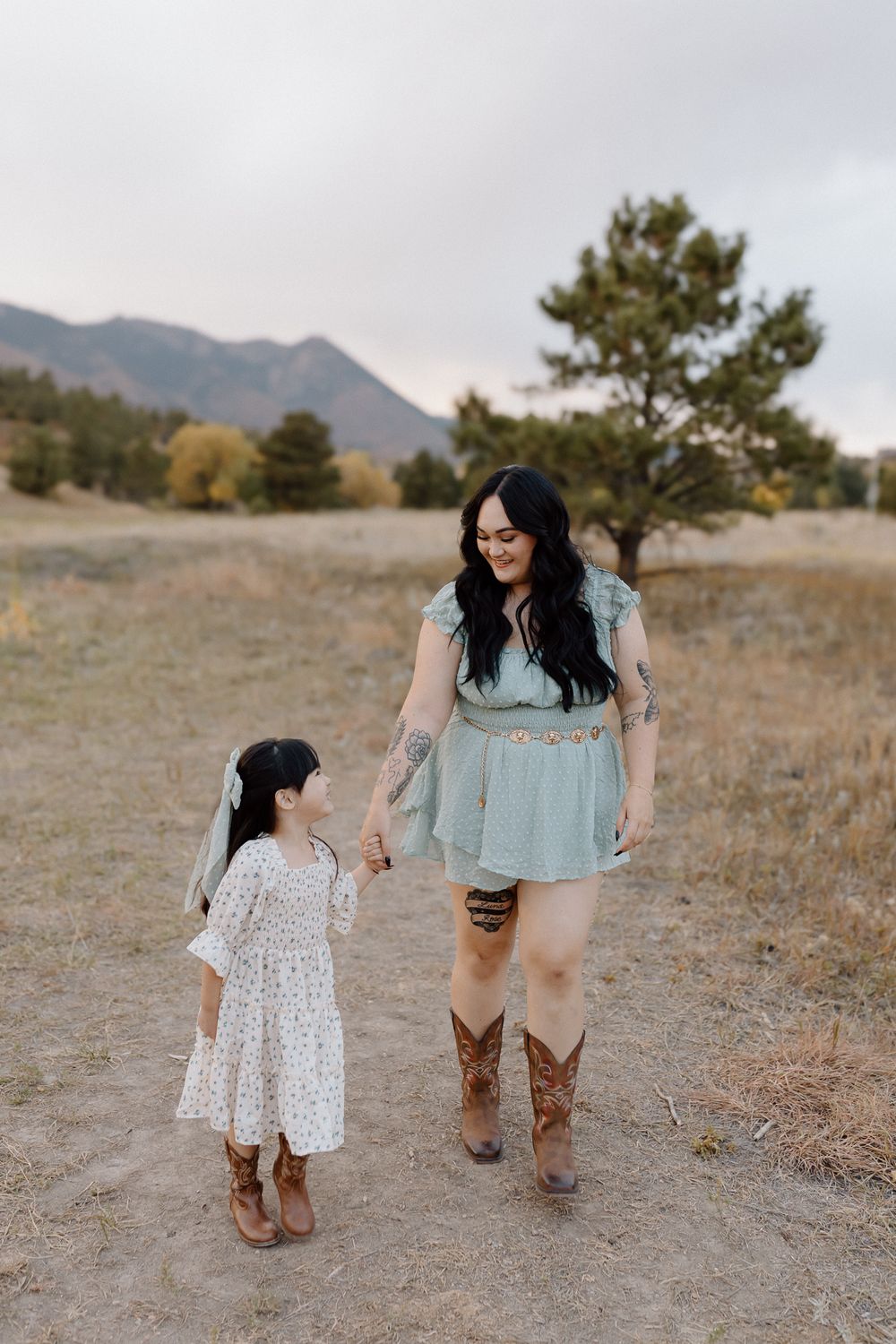 Sweet matching outfits and boots while walking together in a mountain meadow. Colorado Springs Photographer.