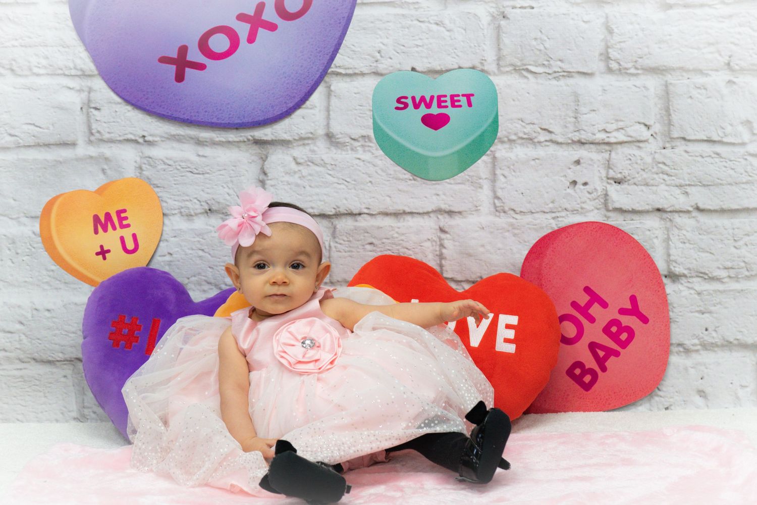 Valentine's themed photography backdrop with conversation heart decorations.