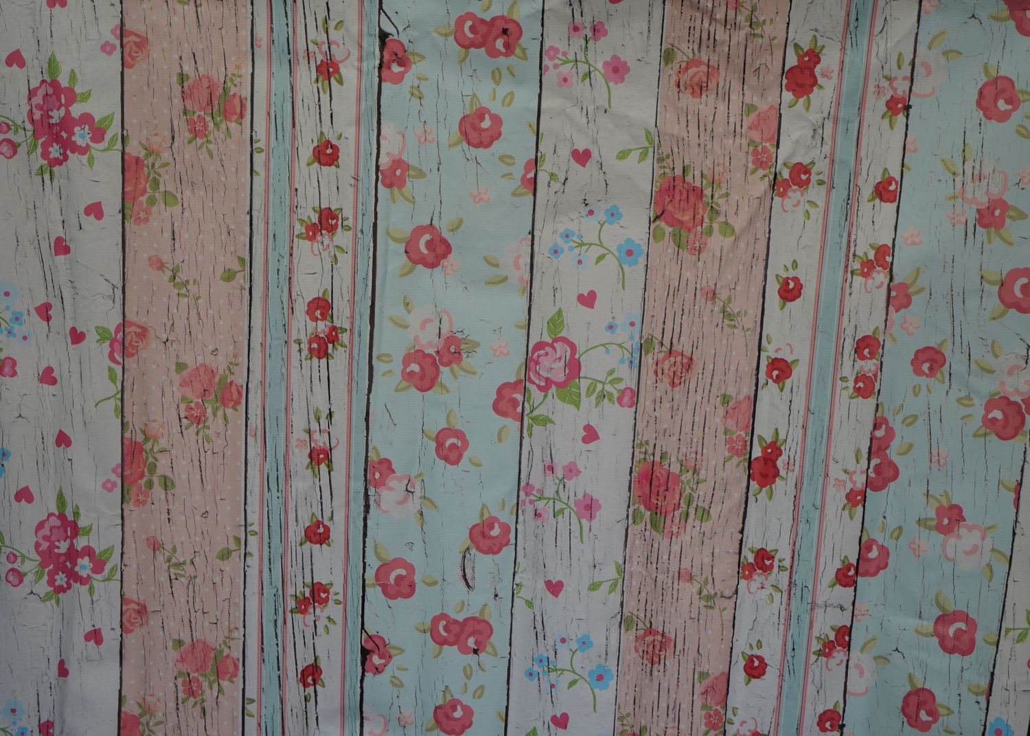 Shabby chic wallpaper with pink floral pattern on distressed wood background.