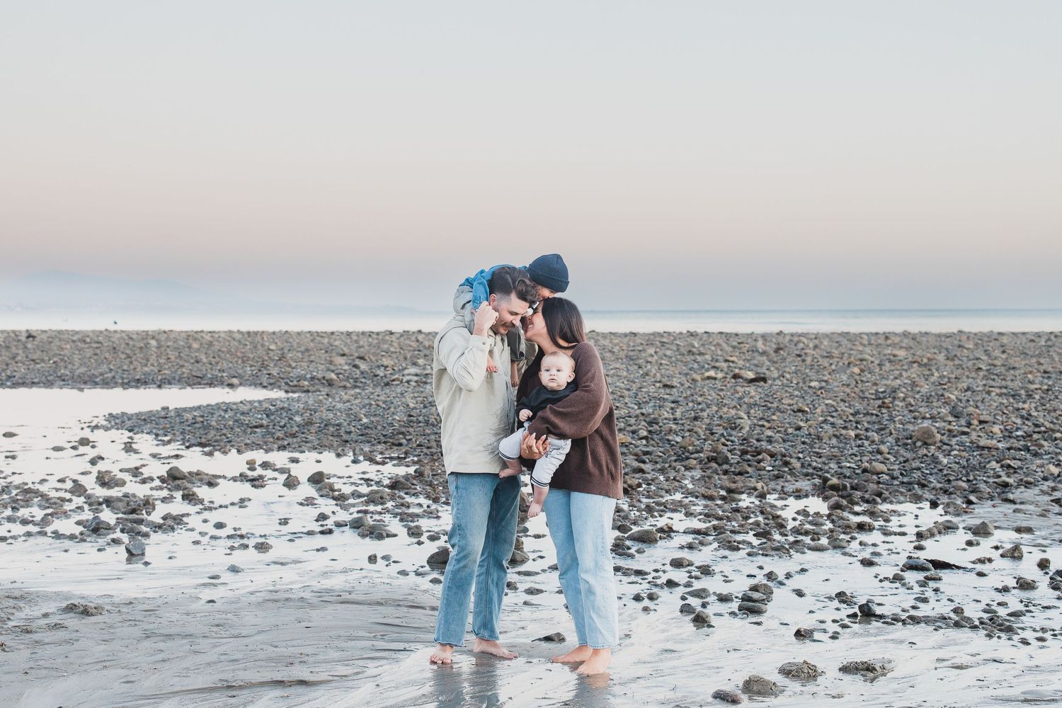 A romantic winter moment on snowy rocky beach at dusk.
