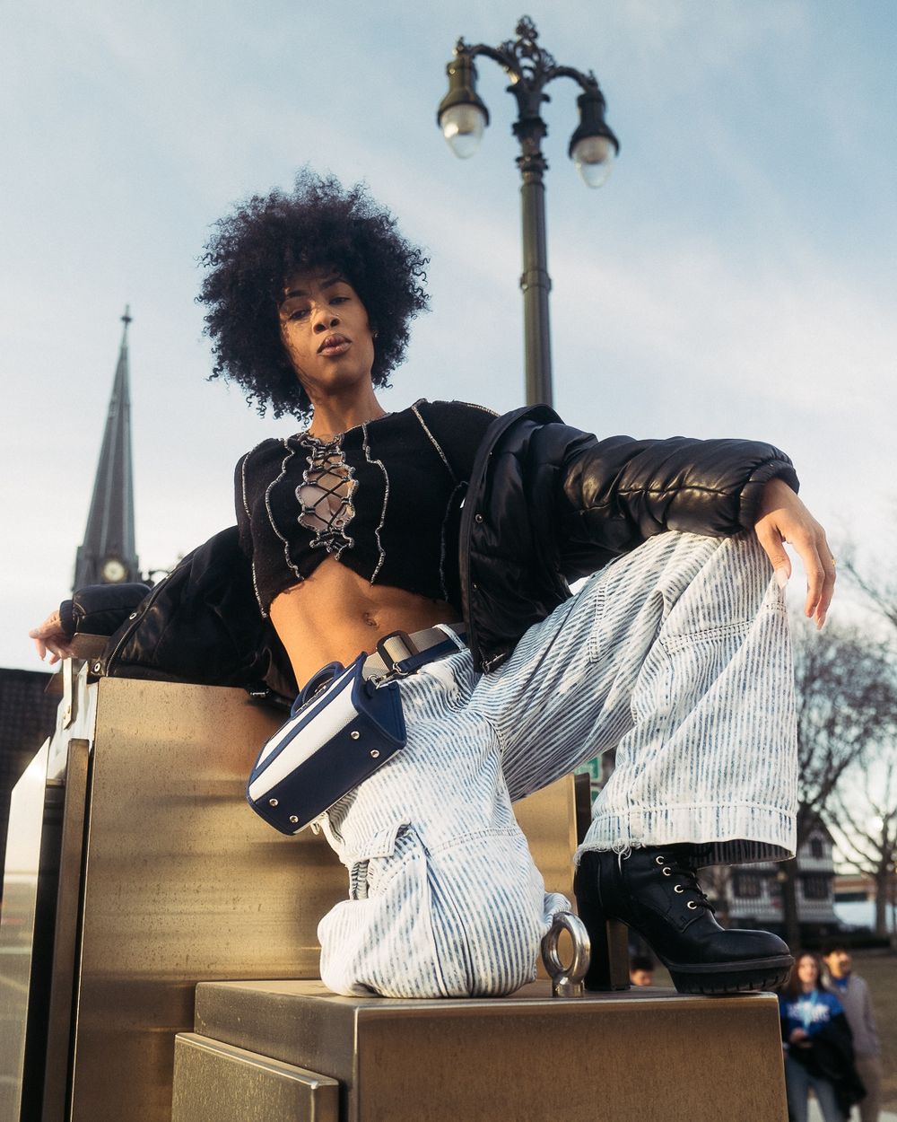 Editorial fashion shot showcasing street style outfit against architectural backdrop.