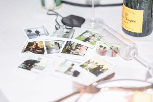 polaroids from the day on an undone tablescape with details from the day. champagne glass tipped over.