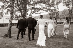 Wedding party walking away from the camera by the water