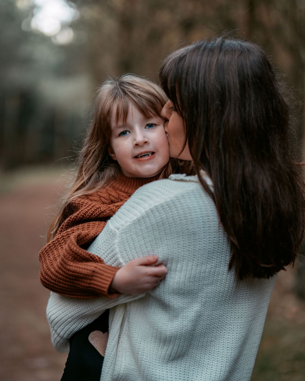 A tender moment between parent and child in cozy winter sweaters.