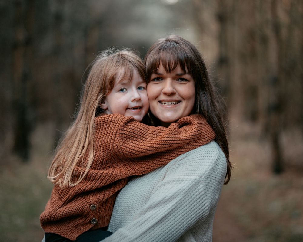 Sweet embraces and laughter between parent and child in cozy autumn sweaters.
