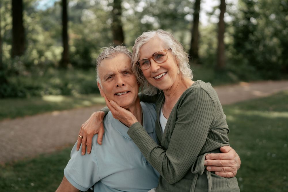Candid outdoor family portrait shots showing warm embraces and genuine smiles.