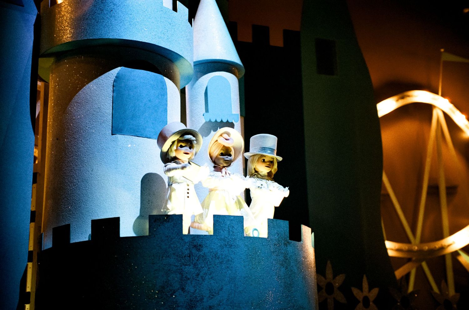 Small animatronic figures in a blue castle tower display at Disney World's Small World attraction.