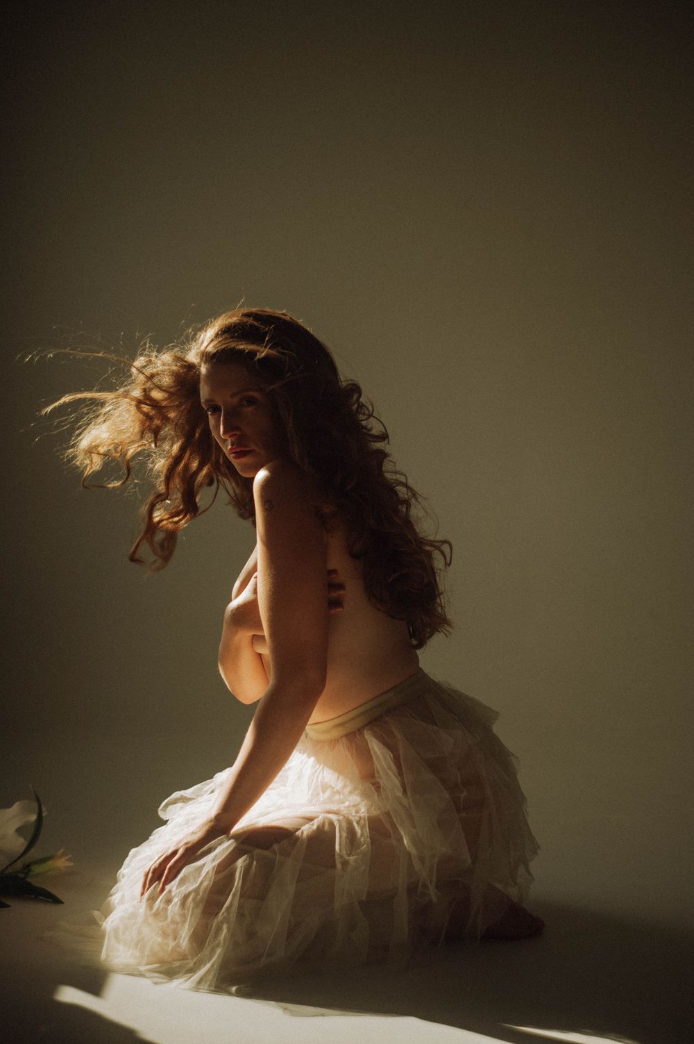 Artistic portrait with flowing hair and white dress in golden light.