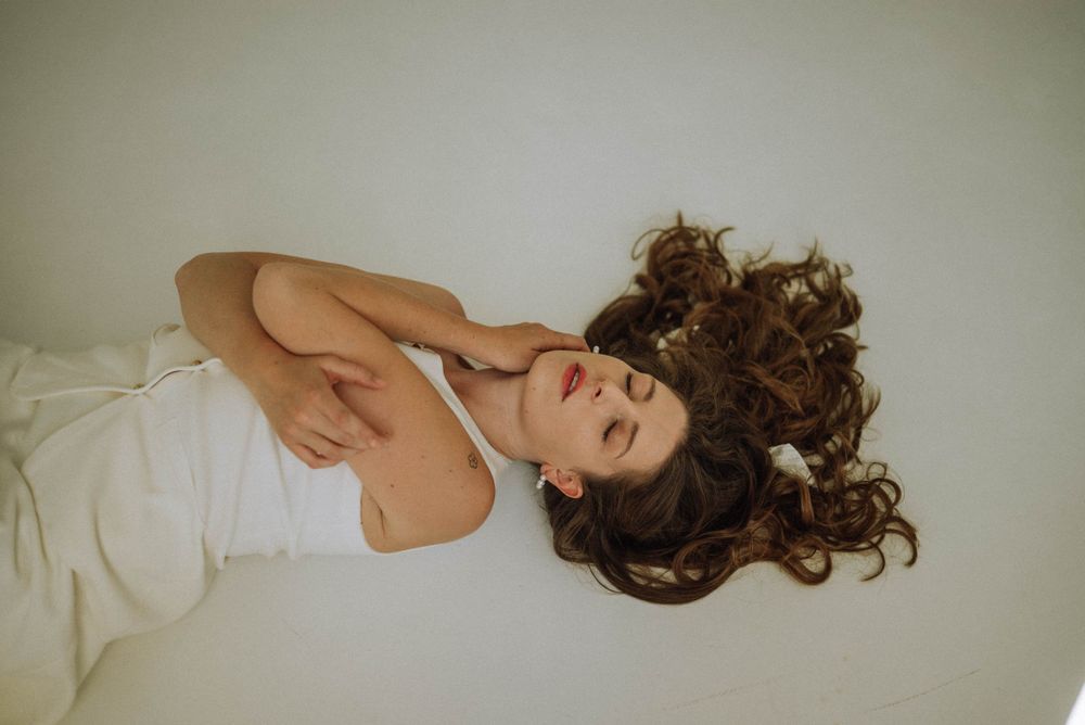 Ethereal portrait series with figure in white clothing against neutral backdrop.
