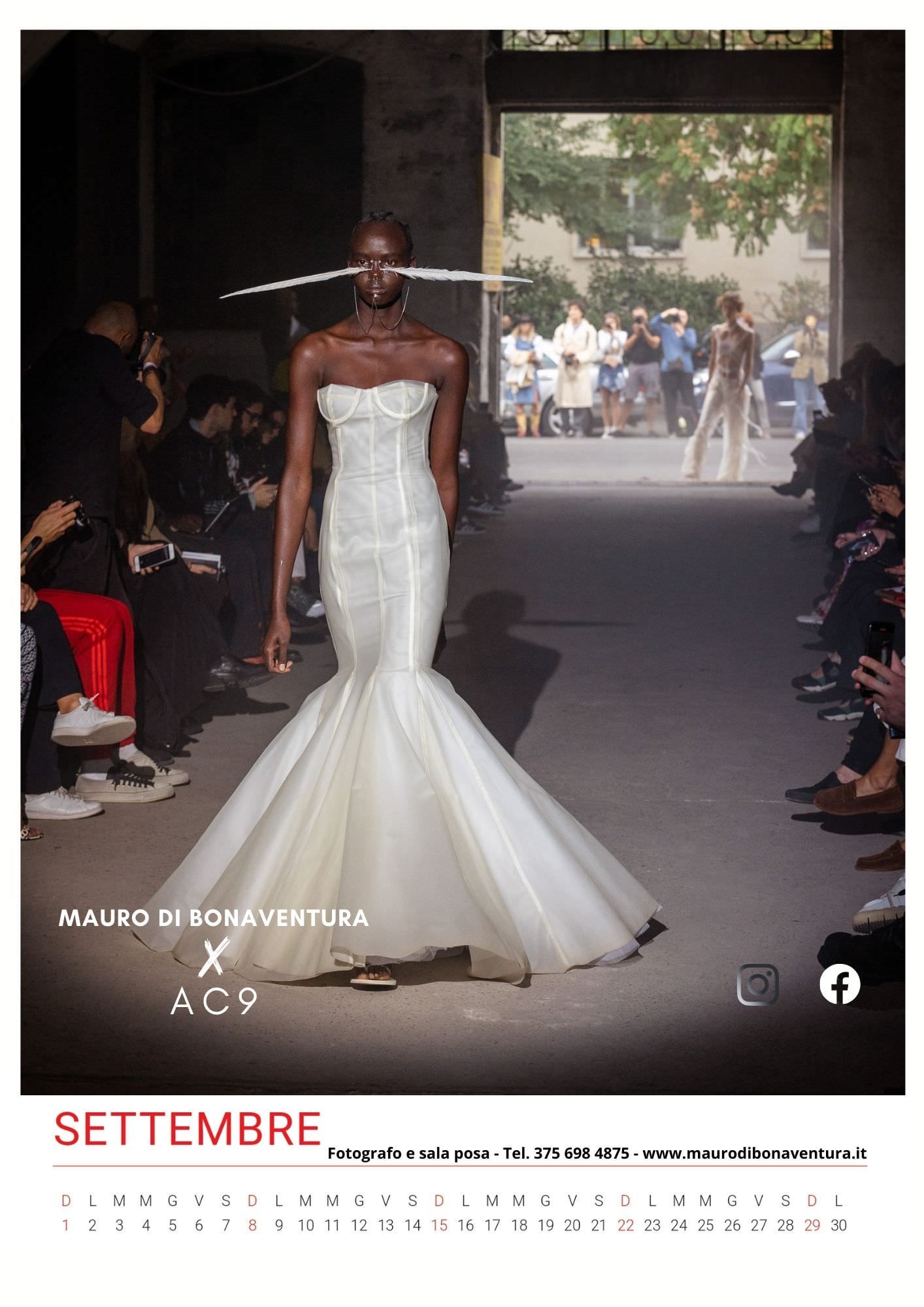 White mermaid wedding gown with strapless bodice shown on fashion runway.