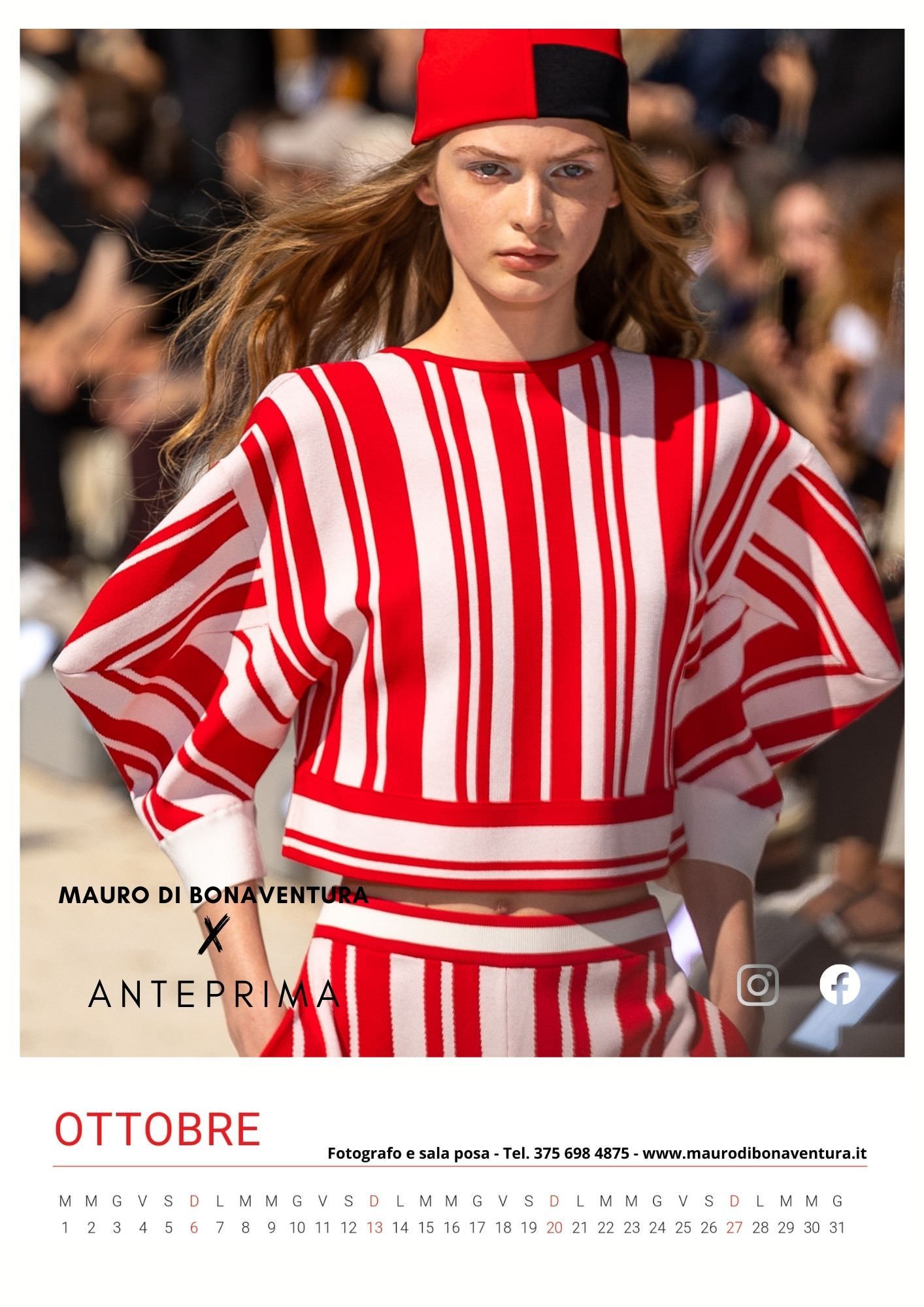 Model in red and white striped outfit with red cap walking fashion runway.