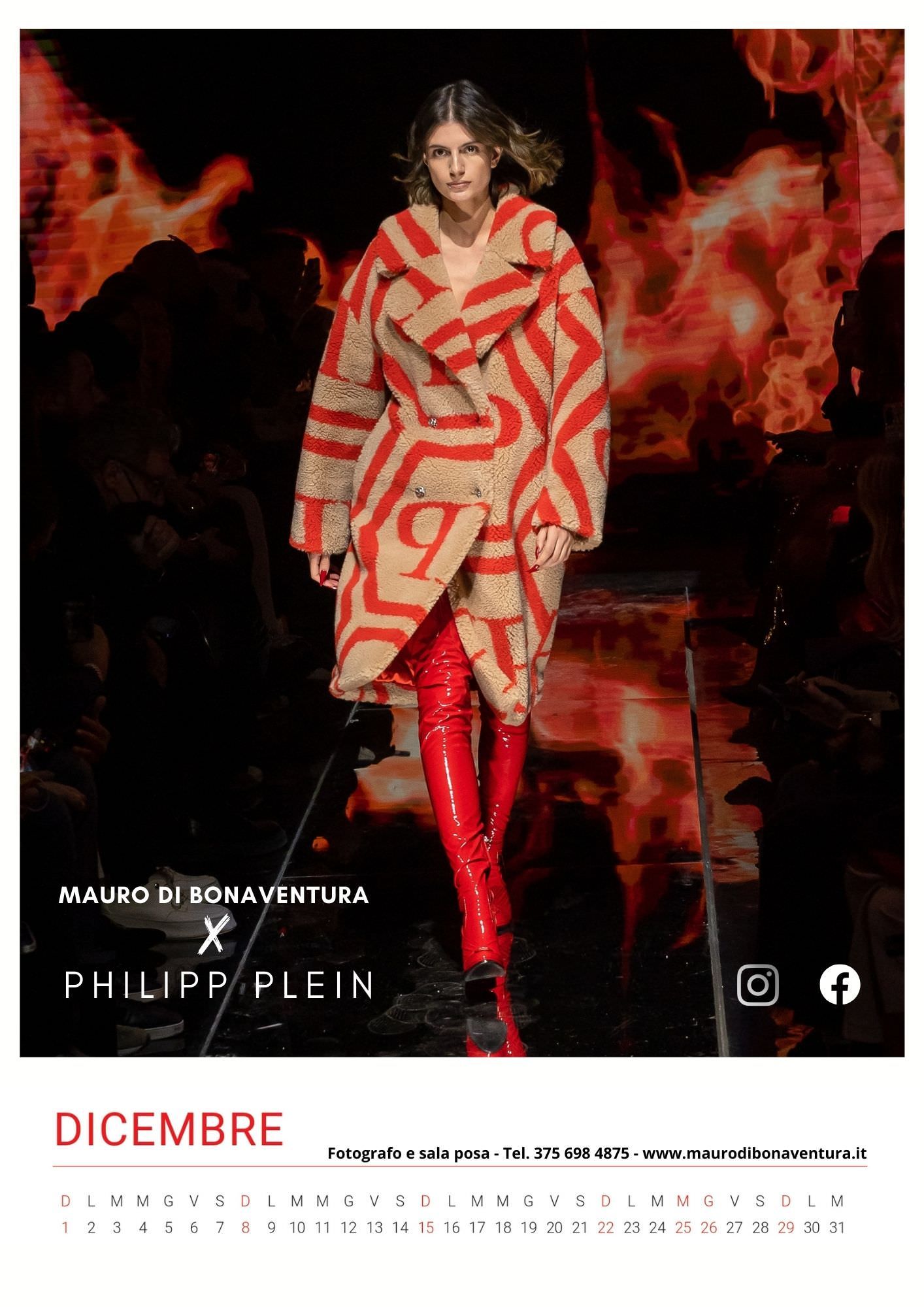 Red and beige striped coat with matching boots against dramatic fiery background on catwalk.