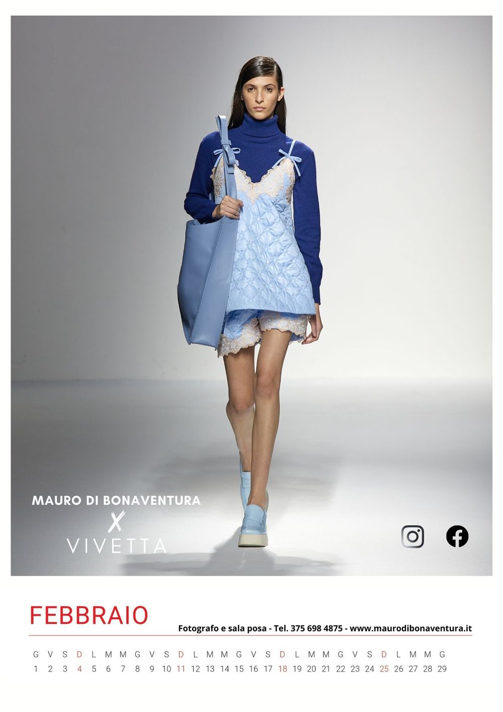 Light blue slip dress layered over navy turtleneck sweater on white runway.