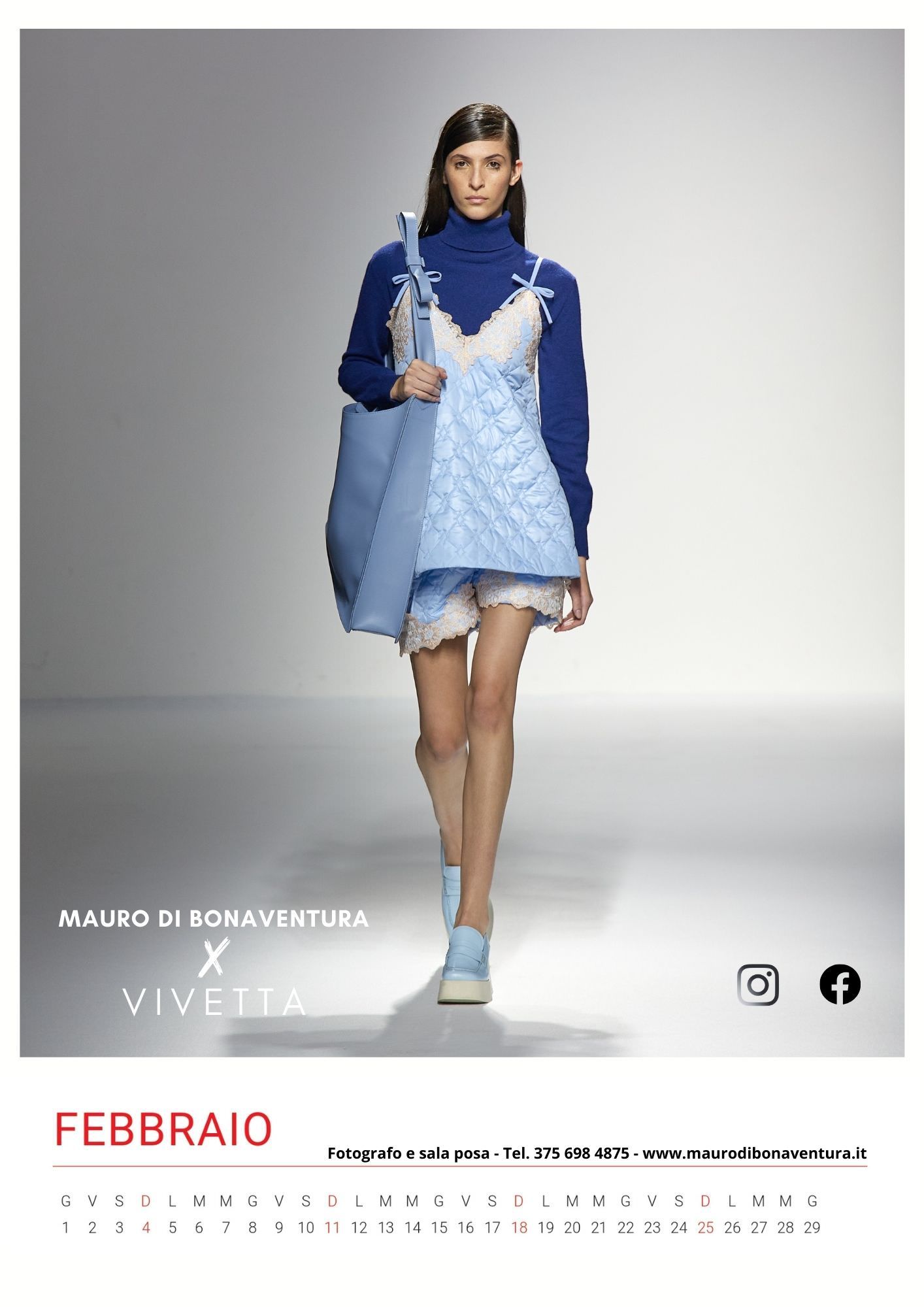 Light blue slip dress layered over navy turtleneck sweater on white runway.