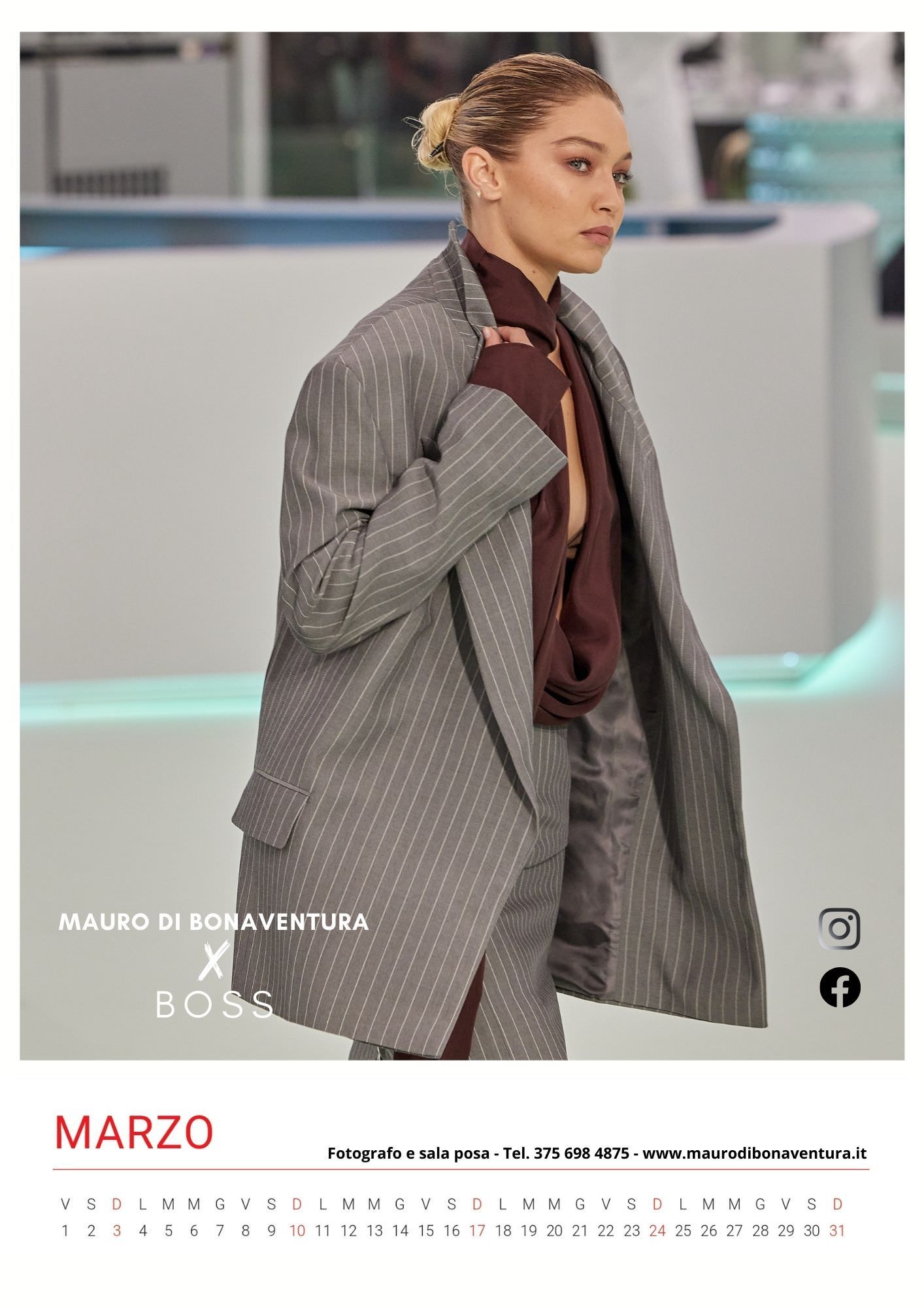 Grey pinstriped oversized blazer with burgundy scarf on minimalist runway.