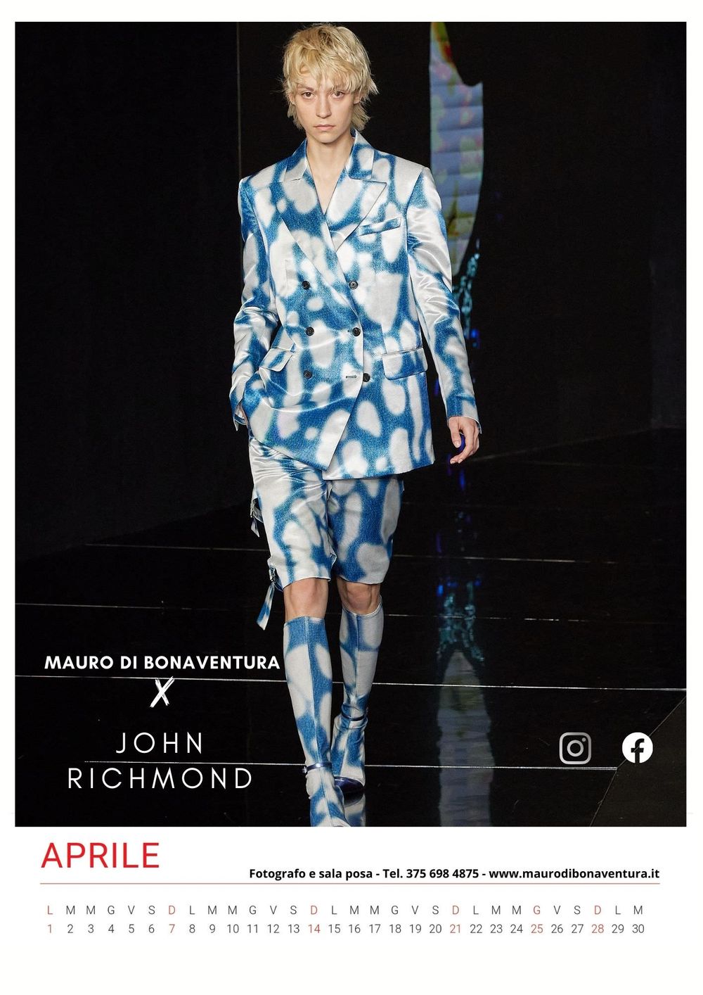 Blue and white tie-dye print suit with matching boots on dark runway.