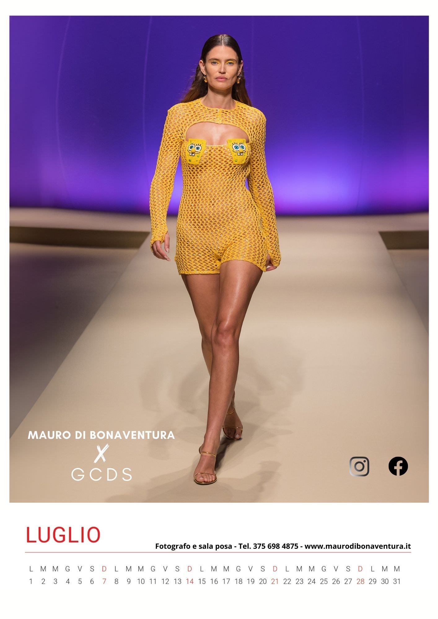 Yellow knit mini dress with cutout details shown on fashion runway with purple backdrop.
